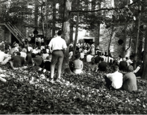 Overflow crowd standing and sitting on the lawn outside the building where Dr. Martin Luther King, Jr. spoke on campus at Duke University in 1964.